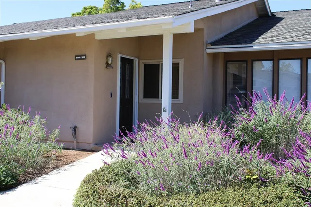 front view of a house with a lot of flower plants