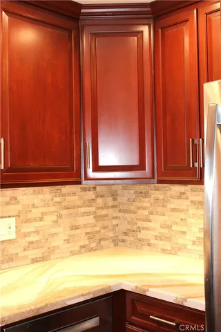 a metallic refrigerator freezer sitting inside of a kitchen