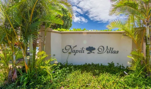 a sign that is on a brick wall with a small yard