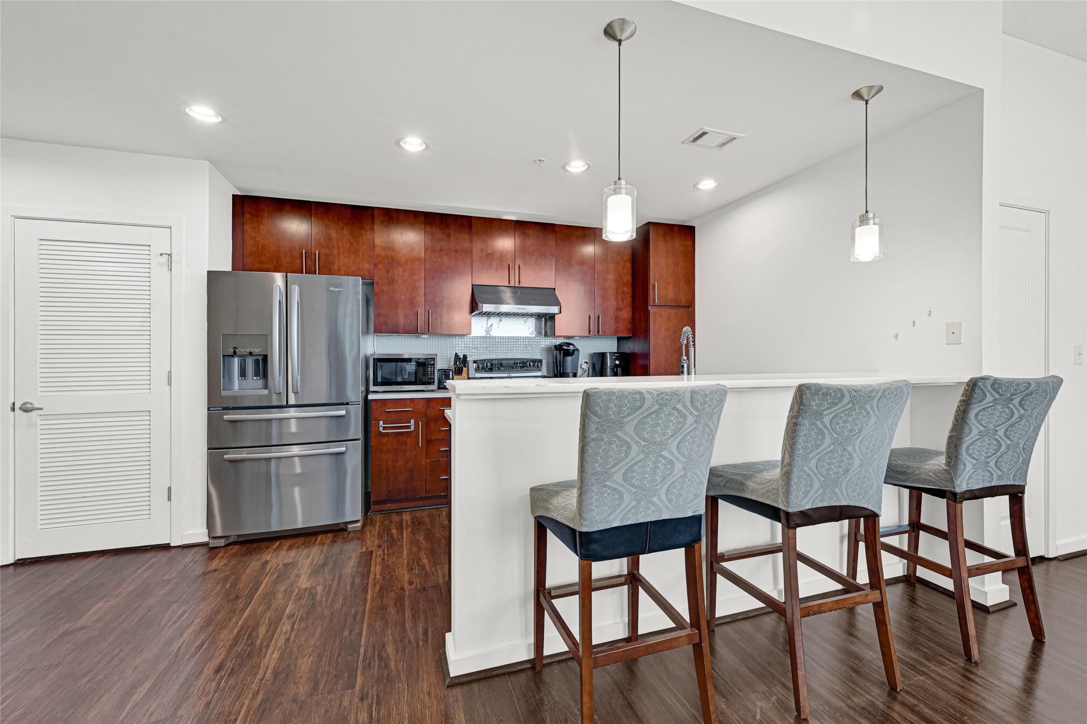 5925 Almeda Road, Unit 11901 Houston, TX 77004 - Photo 9 of 38 a kitchen with stainless steel appliances a dining table chairs refrigerator and microwave
