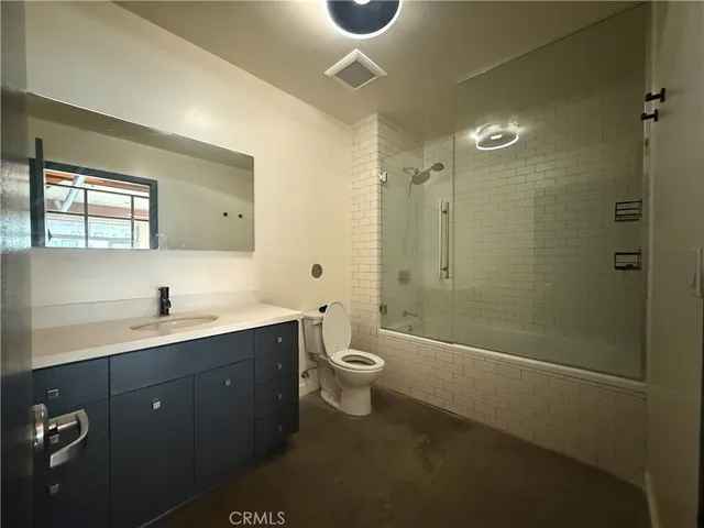a bathroom with a double vanity sink toilet and shower