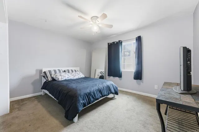 a spacious bedroom with a bed and a chandelier