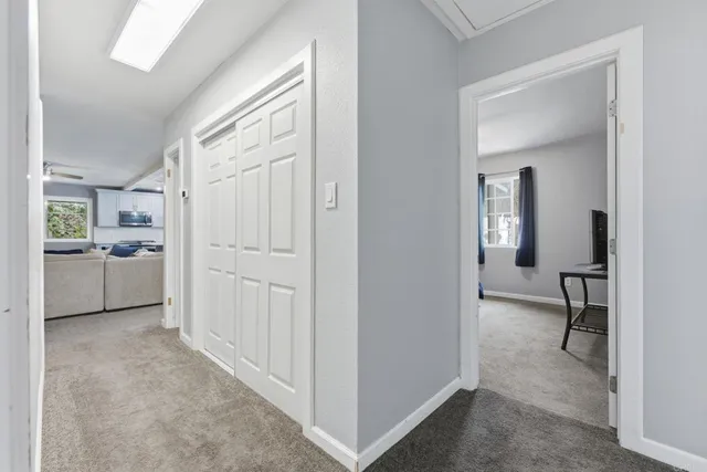 a view of a hallway with a livingroom and a livingroom with furniture