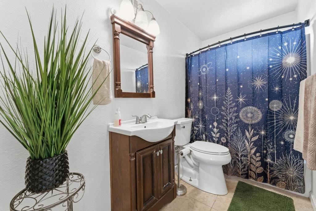 10019 Tamil Road Lakeside, CA 92040 - Photo 15 of 22 a bathroom with a toilet a sink and mirror