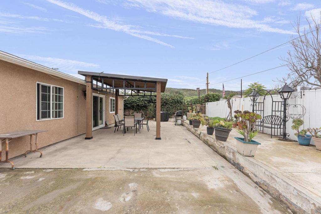 10019 Tamil Road Lakeside, CA 92040 - Photo 21 of 22 a view of a patio with table and chairs under an umbrella with wooden roof