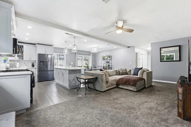 a living room with furniture and kitchen view