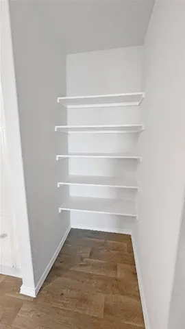 a view of walk in closet with empty racks