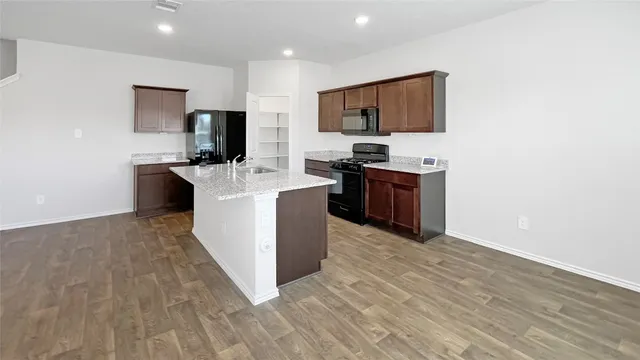 a kitchen with stainless steel appliances a stove top oven a sink a refrigerator and a microwave