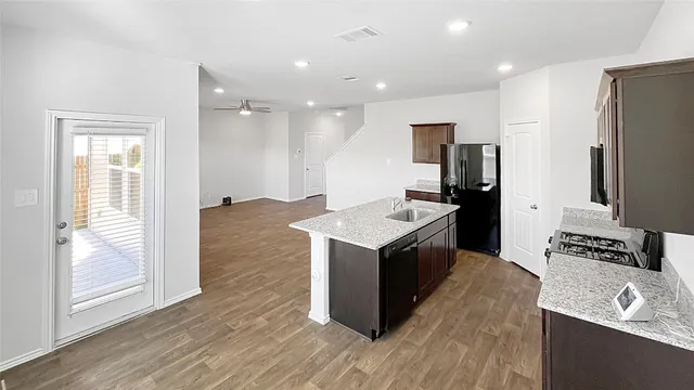 a kitchen with stainless steel appliances granite countertop a sink stove and refrigerator