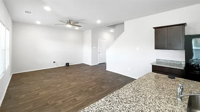 a view of a livingroom with wooden floor and a kitchen space