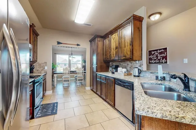 a kitchen with stainless steel appliances granite countertop lots of counter top space and wooden floor
