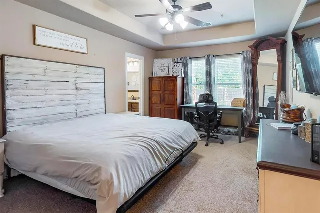 a bedroom with a bed and a flat tv screen on the dresser