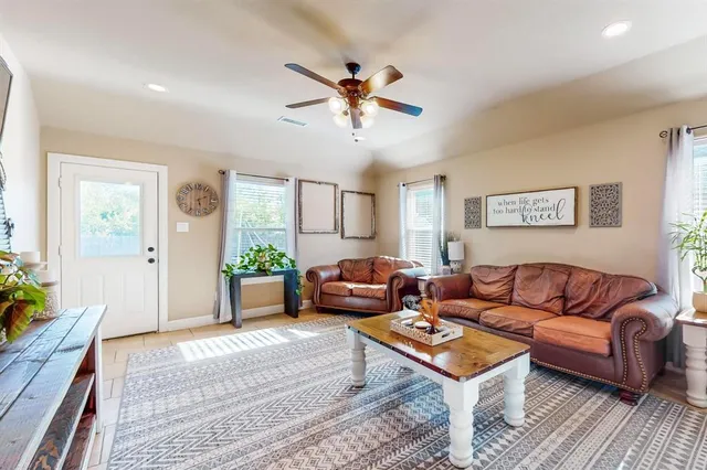 a living room with furniture a ceiling fan and a window