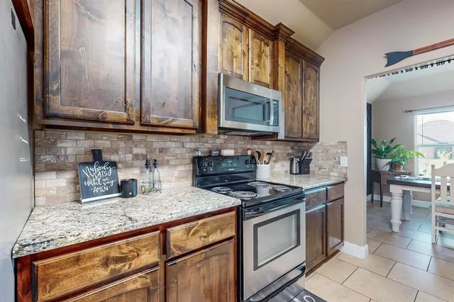 a kitchen with granite countertop a stove sink and cabinets