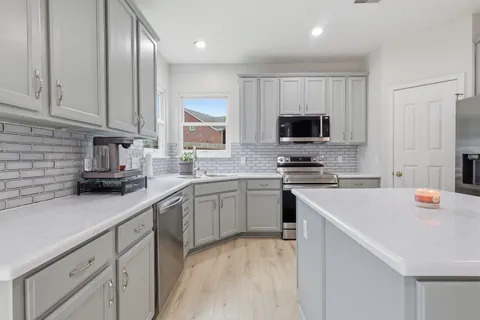a kitchen with white cabinets and stainless steel appliances