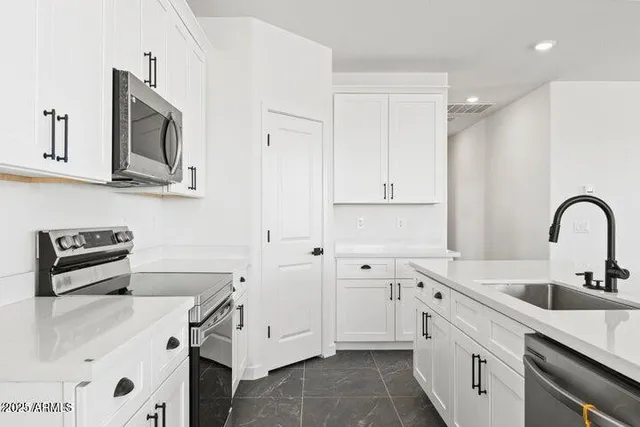 a kitchen with appliances a sink and cabinets