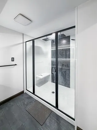 a bathroom with a glass shower door and a mirror
