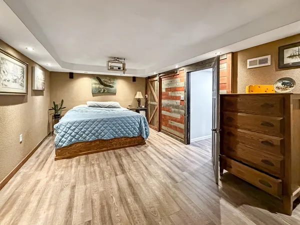 a bedroom with a bed and wooden floor