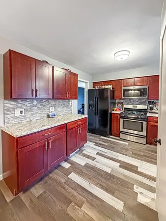 a kitchen with stainless steel appliances granite countertop a refrigerator and a stove top oven
