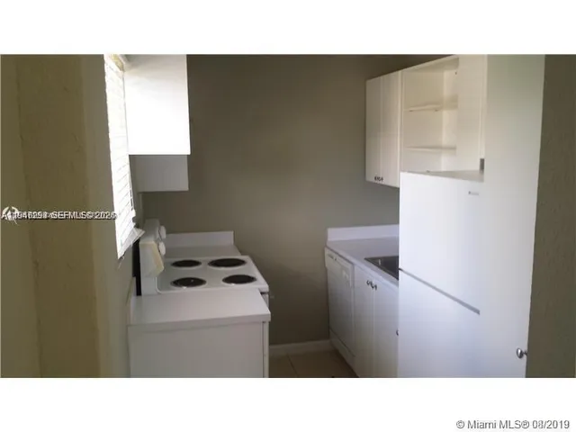 a kitchen with a sink a refrigerator and window