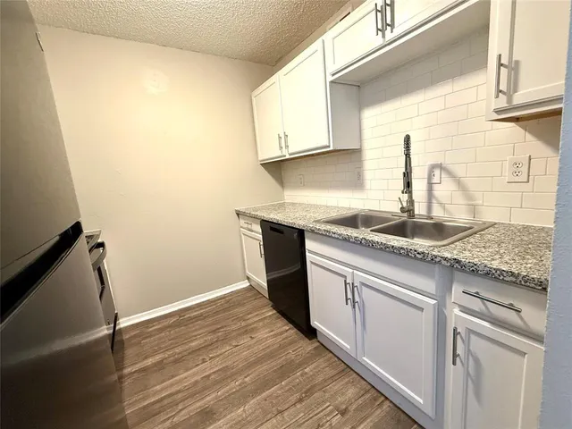 a kitchen with granite countertop cabinets stainless steel appliances and a sink