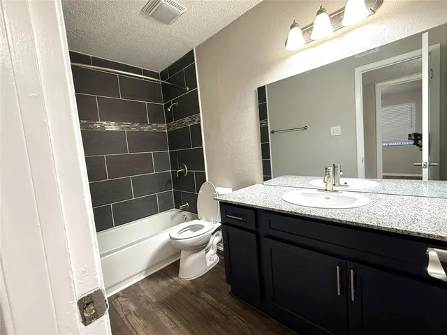 a bathroom with a sink a toilet a mirror and shower