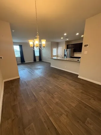 a view of a living room a kitchen with wooden floor and a kitchen