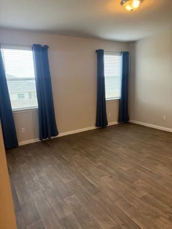 an empty room with windows and closet