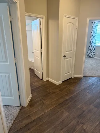 an empty room with wooden floor and entrance