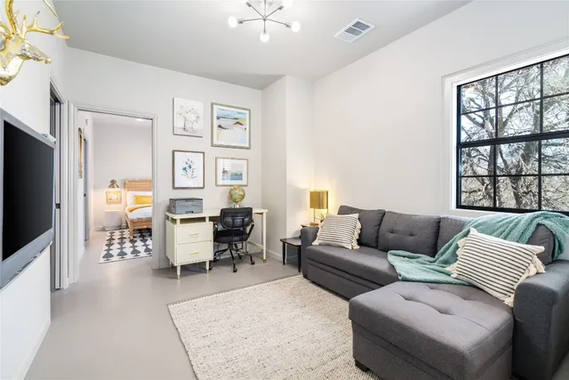 a bedroom with a bed and large windows