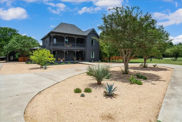 a view of a white house with a yard