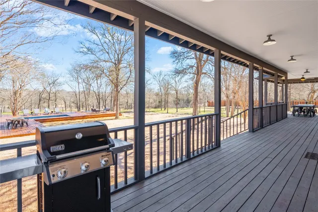 a view of swimming pool with a bench and trees in the background