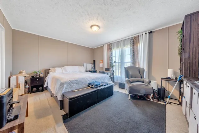 a spacious bedroom with a bed couch and a window