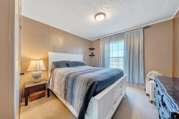 a bedroom with a bed and a dresser with mirror