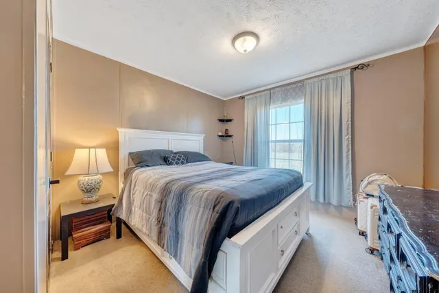 a bedroom with a bed and a dresser with mirror