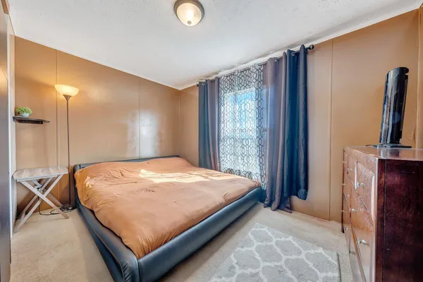 a bed sitting in a bedroom next to a window