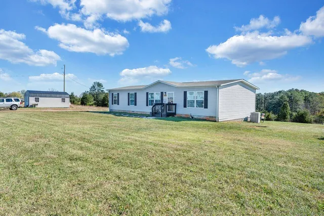 a view of a house with a big yard and potted plants