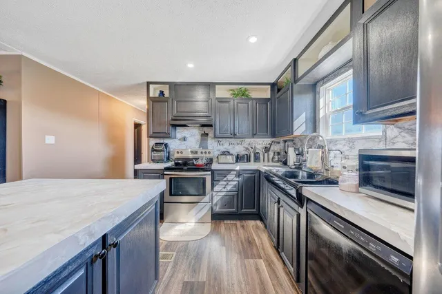 a kitchen with stainless steel appliances granite countertop a sink stove and refrigerator