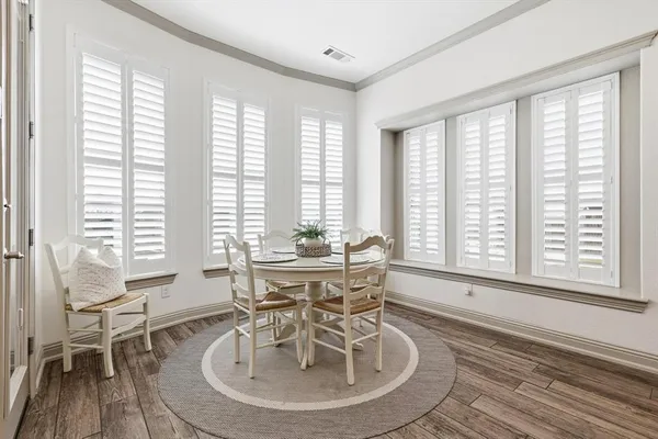 a dining room with wooden floor and furniture