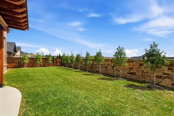 a view of a house with a big yard plants and large trees