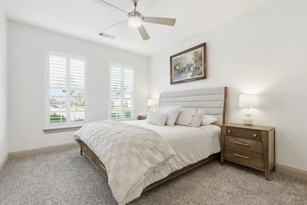 a bedroom with a bed dresser and window