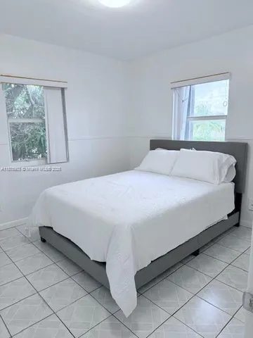 a large bed sitting in a bedroom next to a window