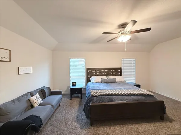 a bedroom with a bed a couch and chandelier