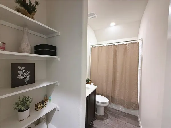 a bathroom with a toilet a sink and shower curtain