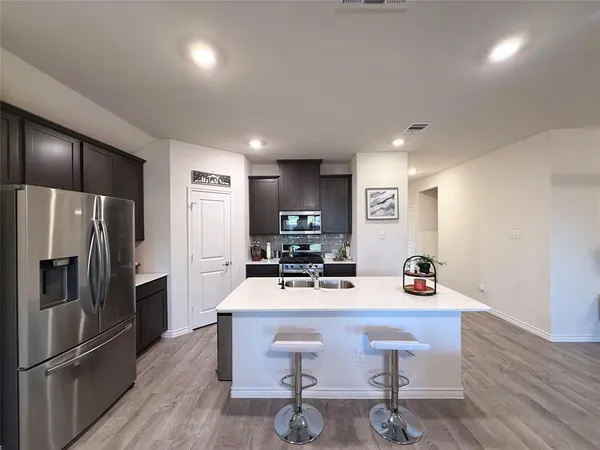a kitchen with stainless steel appliances a refrigerator and a stove top oven