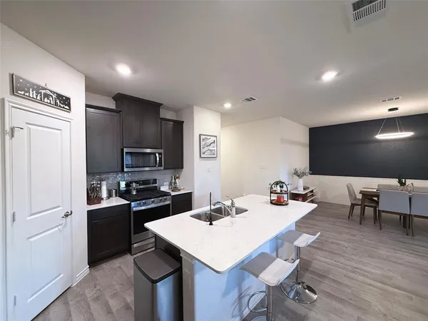 a kitchen with a sink a counter space and stainless steel appliances