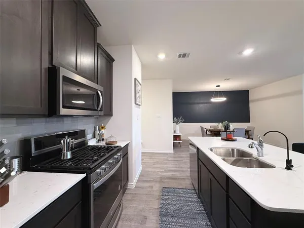 a kitchen with stainless steel appliances a sink stove and microwave