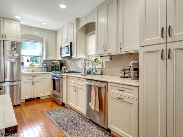 a kitchen with white cabinets and white appliances