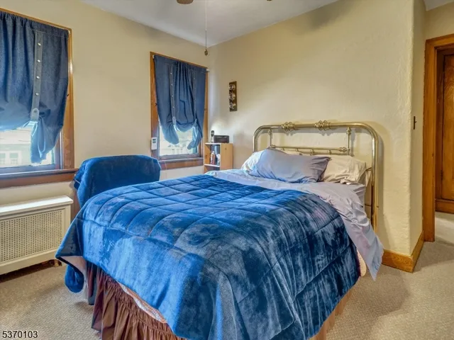 a bedroom with a bed and painting on the wall