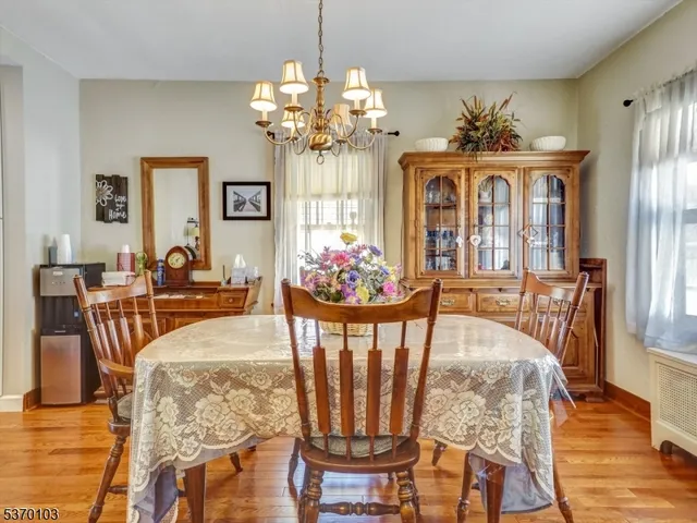 a view of a dining room with furniture a chandelier and wooden floor